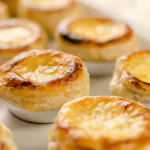 Empadinhas de queijo douradas em uma bandeja branca