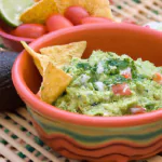 Uma tigela de guacamole com nachos ao lado