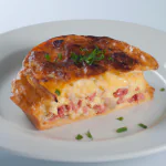 Torta de liquidificador dourada servida em um prato.